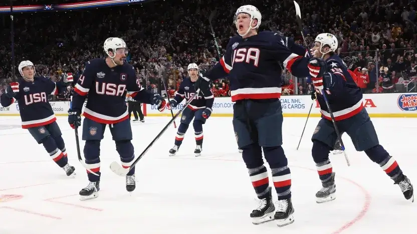 Team USA men's players celebrating a goal at the Four Nations Tournament.