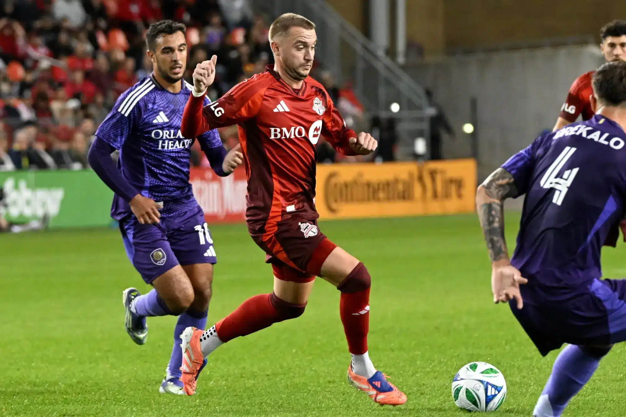 Oct 18, 2025; Toronto, Ontario, CAN; Toronto FC midfielder Djordje Mihailovic (10) moves the ball away from Orlando City forward Martin Ojeda (10) in the second half at BMO Field.