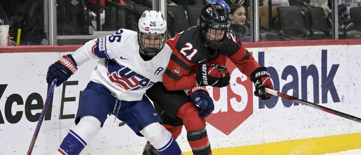 Team USA forward Alex Carpenter (25) and Team Canada defense Ashton Bell (21) battle for the puck during the first period of a Rivalry Series women's ice hockey game at Xcel Energy Center.