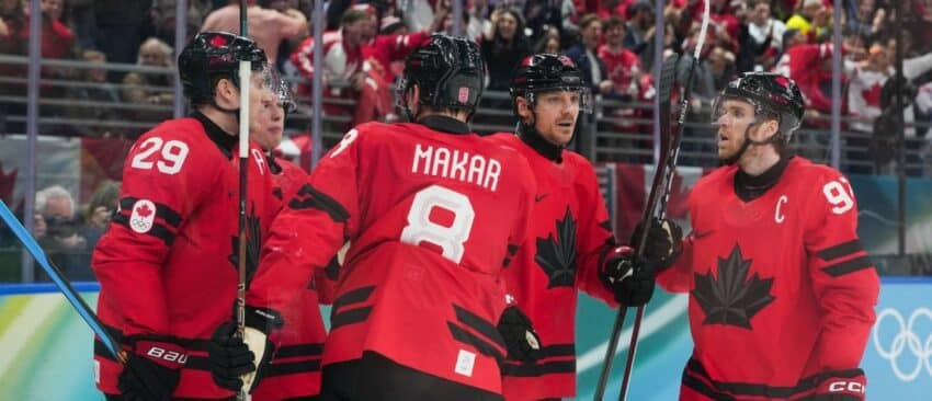 Cale Makar (8) of Canada celebrates with Nathan MacKinnon (29) of Canada and Sam Reinhart (13) of Canada after assisting a goal during the second period against Finland in a men's ice hockey semifinal during the Milano Cortina 2026 Olympic Winter Games at Milano Santagiulia Ice Hockey Arena