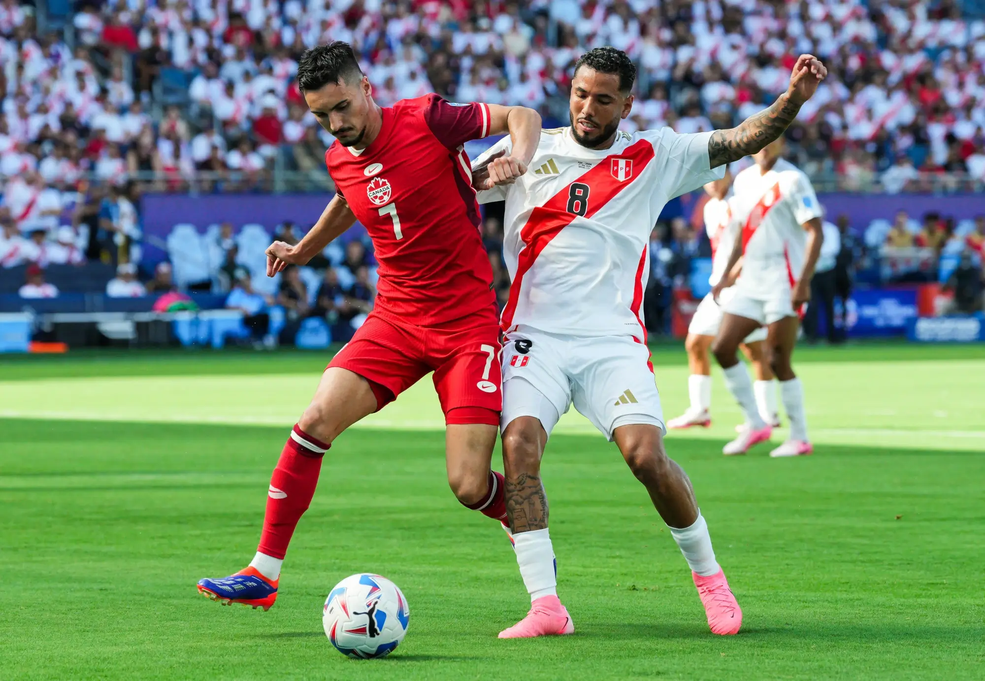 Jun 25, 2024; Kansas City, KS, USA; Canada midfielder Stephen Eustaquio (7) and Peru midfielder Sergio Pena (8) fight for the ball during the first half of a Copa America match at Children's Mercy Park. 