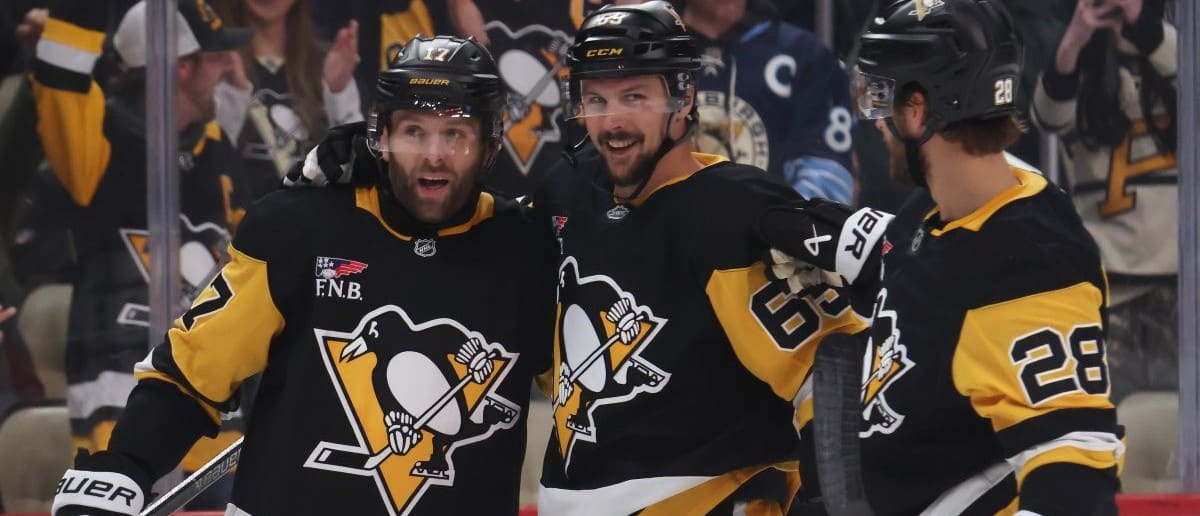 Pittsburgh Penguins right wing Bryan Rust (17) celebrates his second goal of the game with defensemen Erik Karlsson (65) and Parker Wotherspoon (28) against the St. Louis Blues during the third period at PPG Paints Arena