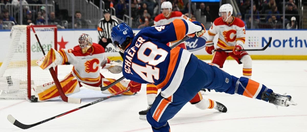 New York Islanders defenseman Matthew Schaefer (48) attempts a shot and Calgary Flames goaltender Dustin Wolf (32) makes a the save during the second period at UBS Arena