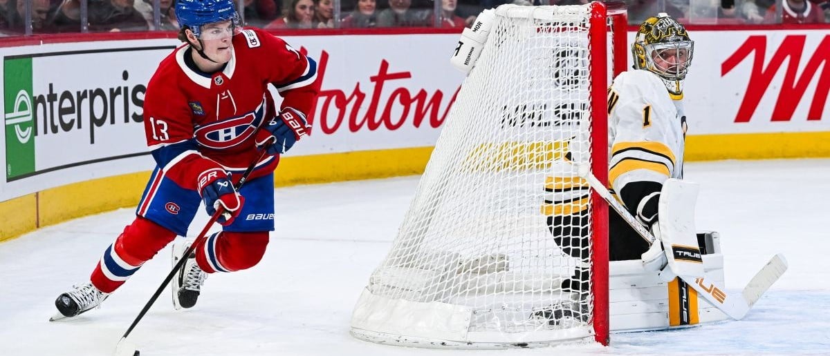 Montreal Canadiens right wing Cole Caufield (13) plays the puck behind Boston Bruins Jeremy Jeremy Swayman (1) net during overtime at Bell Centre