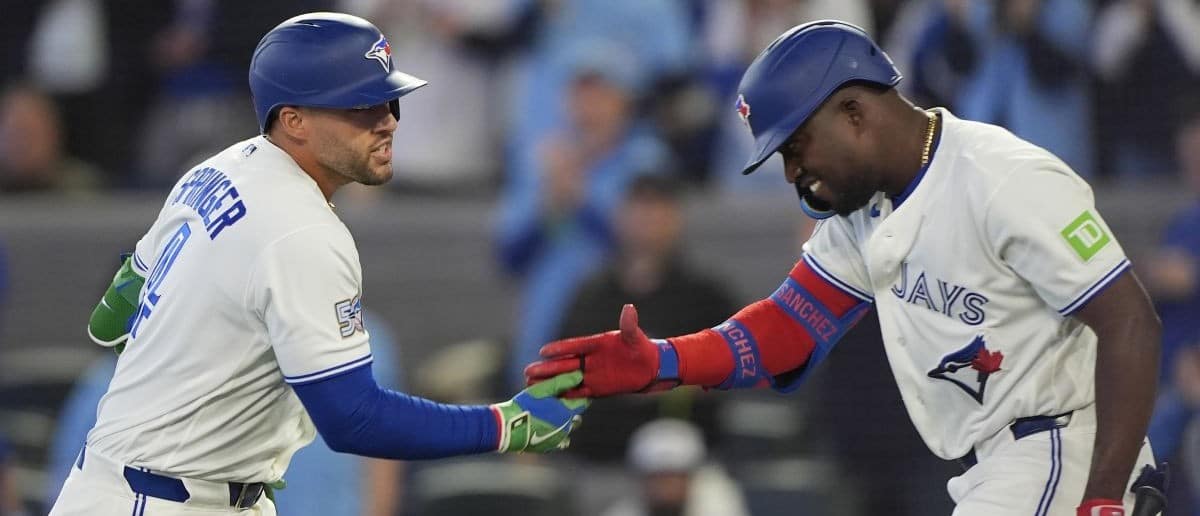 Toronto Blue Jays left fielder Jesus Sanchez (12) congratulates designated hitter George Springer (4) on his solo home run against the Athletics during the first inning at Rogers Centre.