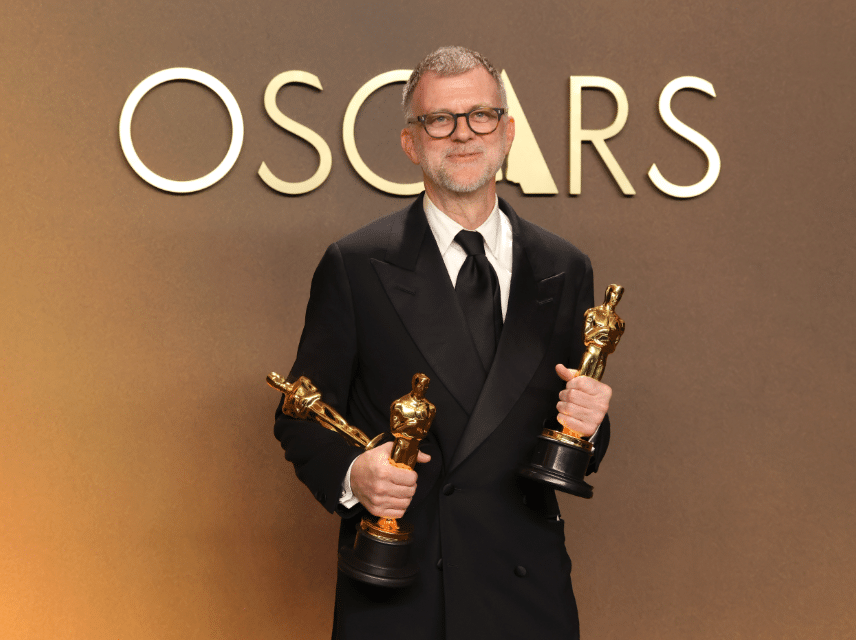 Paul Thomas Anderson holding his Oscars for Best Adapted Screenplay, Best Director, and Best Picture for One Battle After Another.
