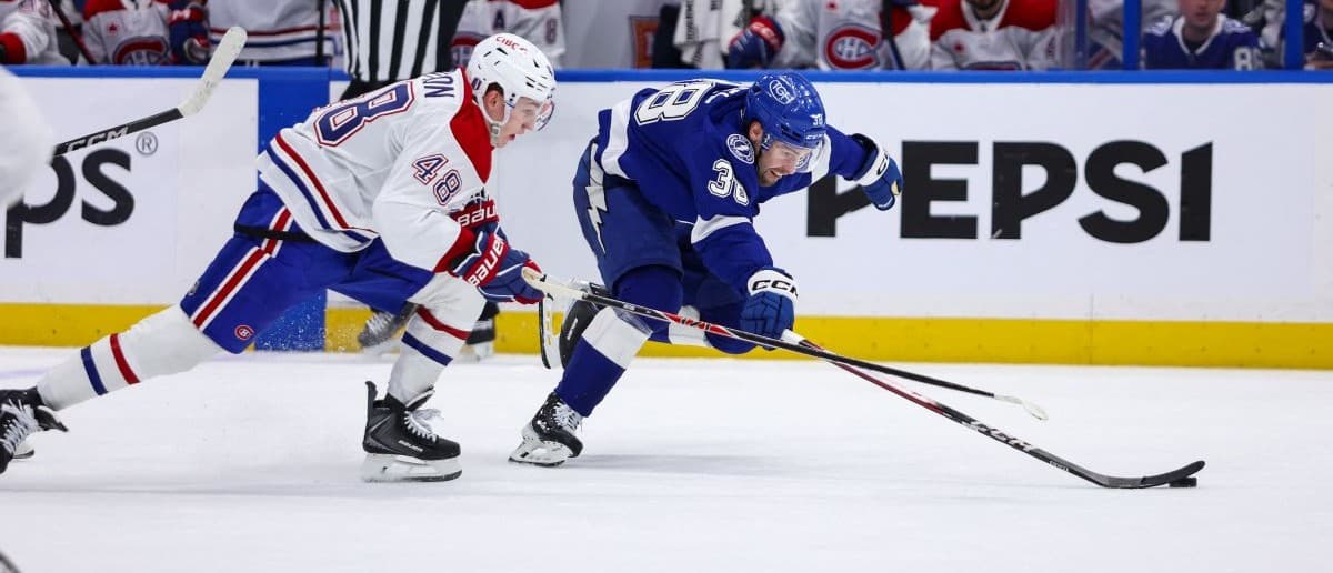 Tampa Bay Lightning forward Brandon Hagel (38) reaches for the puck under pressure from Montreal Canadiens defenseman Lane Hutson (48) during the third period in game one of the first round of the 2026 Stanley Cup Playoffs at Benchmark International Arena.