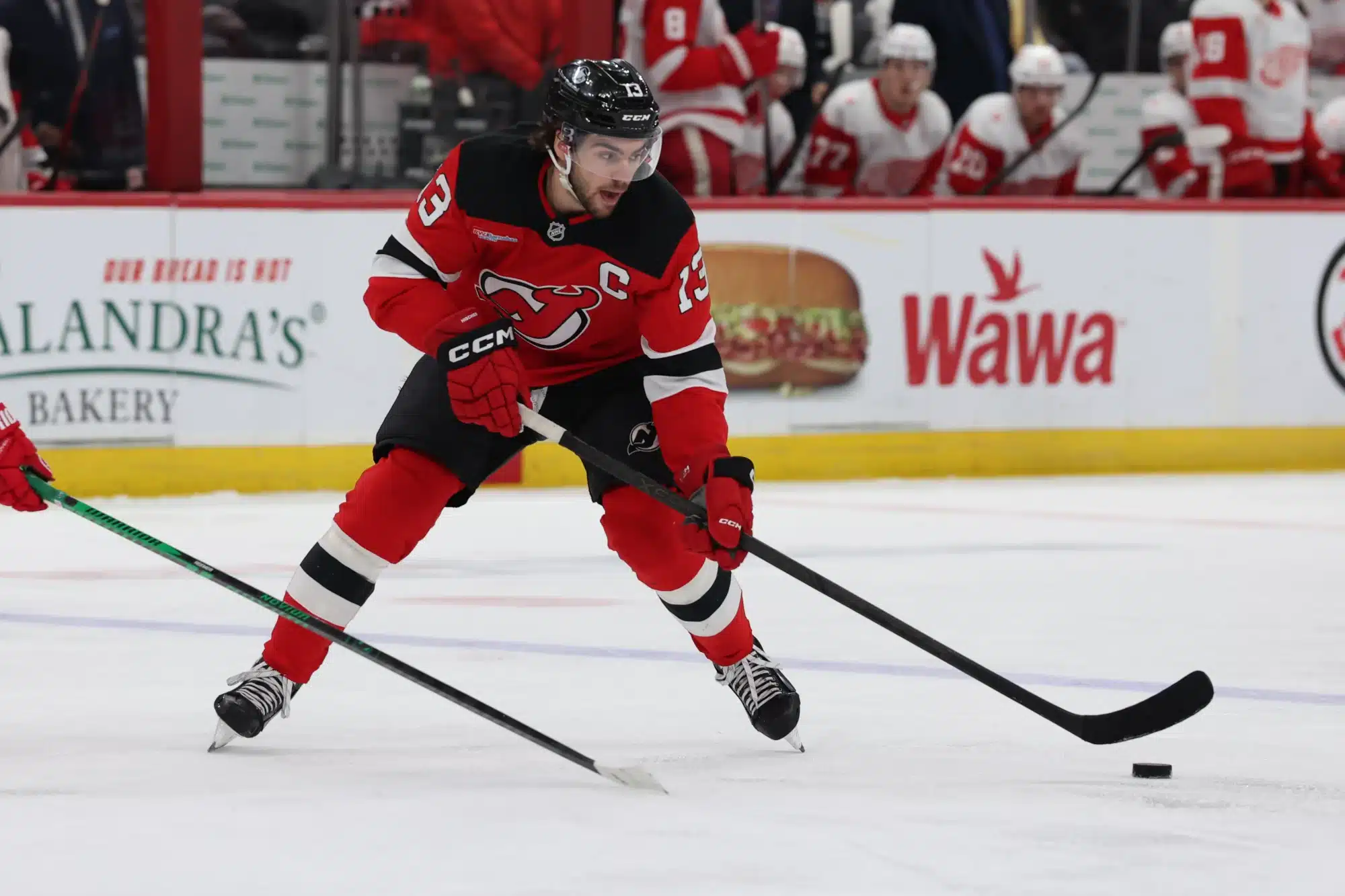 Mar 8, 2026; Newark, New Jersey, USA; New Jersey Devils center Nico Hischier (13) skates with the puck against the Detroit Red Wings during the second period at Prudential Center.