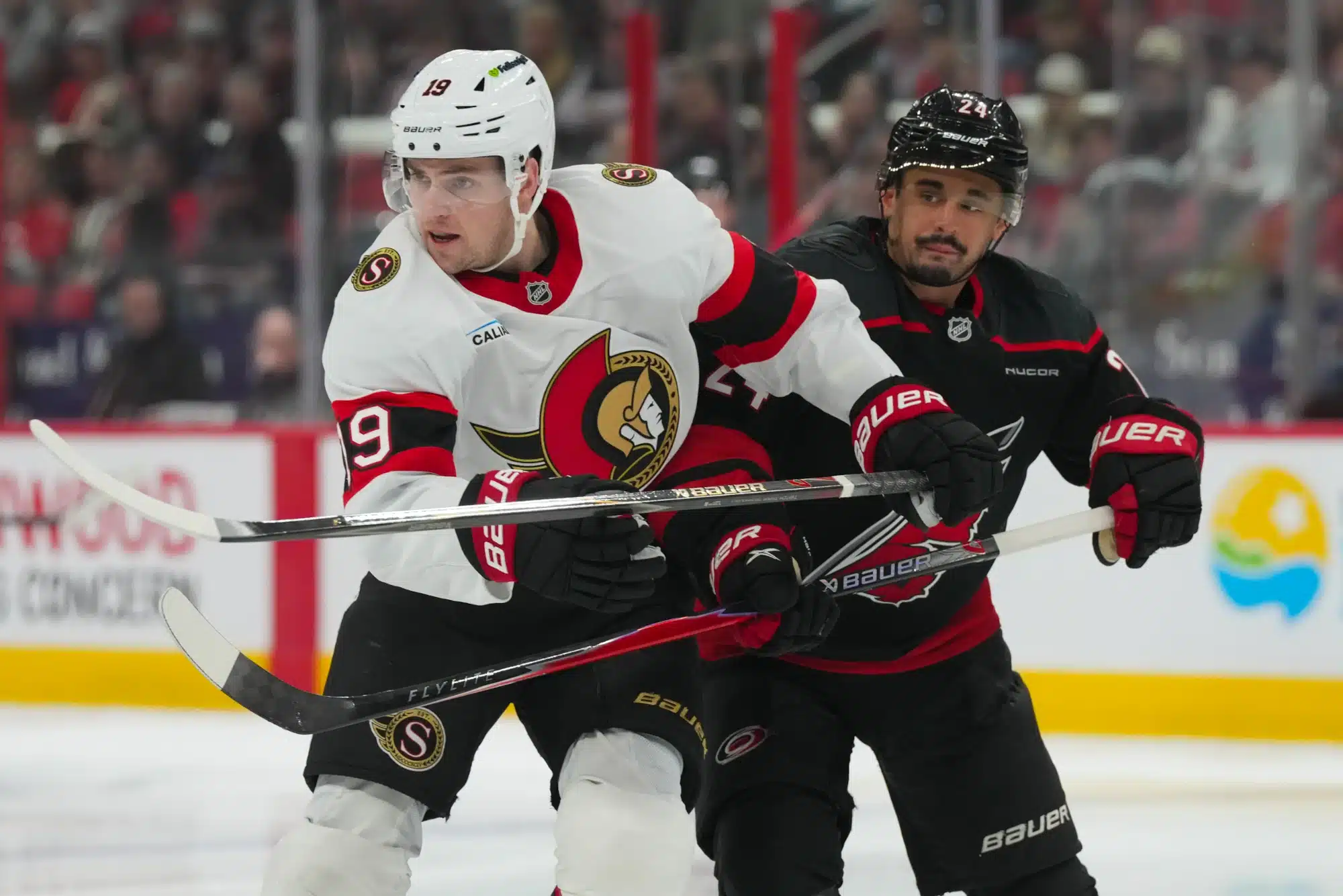 Apr 20, 2026; Raleigh, North Carolina, USA; Carolina Hurricanes center Seth Jarvis (24) and Ottawa Senators right wing Drake Batherson (19) battle in the first overtime period in game two of the first round of the 2026 Stanley Cup Playoffs at Lenovo Center.