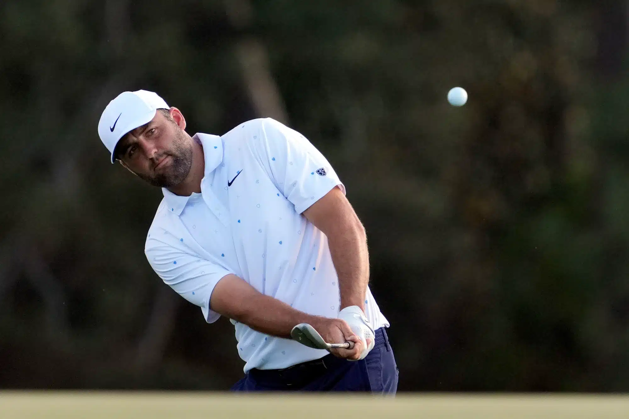Apr 12, 2026; Augusta, Georgia, USA; Scottie Scheffler takes a shot on the 18th hole during the final round of the Masters Tournament at Augusta National Golf Club.