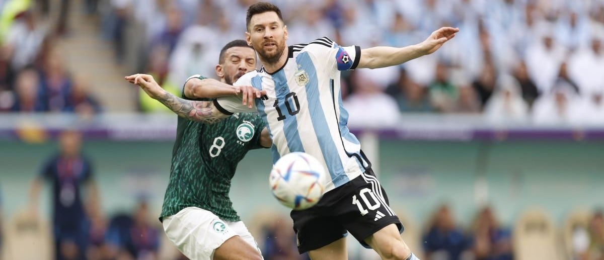 Argentina forward Lionel Messi (10) battles for the ball against Saudi Arabia midfielder Abdulellah Al-Malki (8) during a group stage match during the 2022 World Cup at Lusail Stadium.
