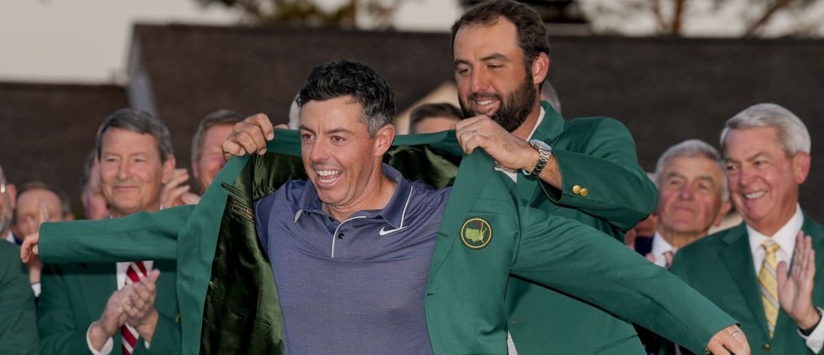 Scottie Scheffler places the green jacket on Rory McIlroy during the green jacket ceremony during the final round of the Masters Tournament at Augusta National Golf Club