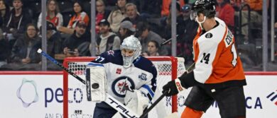 Winnipeg Jets goaltender Connor Hellebuyck (37) makes a save as Philadelphia Flyers center Sean Couturier (14) waits for rebound during the second period at Wells Fargo Center.