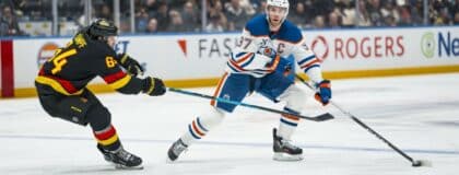 Vancouver Canucks forward David Kampf (64) stick checks Edmonton Oilers forward Connor McDavid (97) in the third period at Rogers Arena