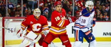 Calgary Flames defenseman Zayne Parekh (19) and Edmonton Oilers left wing Zach Hyman (18) fight for position in front of Calgary Flames goaltender Devin Cooley (1) during the third period at Scotiabank Saddledome