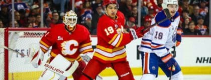 Calgary Flames defenseman Zayne Parekh (19) and Edmonton Oilers left wing Zach Hyman (18) fight for position in front of Calgary Flames goaltender Devin Cooley (1) during the third period at Scotiabank Saddledome