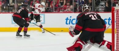 Ottawa Senators center Tim Stützle (18) gets the shot away against Carolina Hurricanes defenseman Sean Walker (26) and goaltender Frederik Andersen (31) during the second period in game one of the first round of the 2026 Stanley Cup Playoffs at Lenovo Center