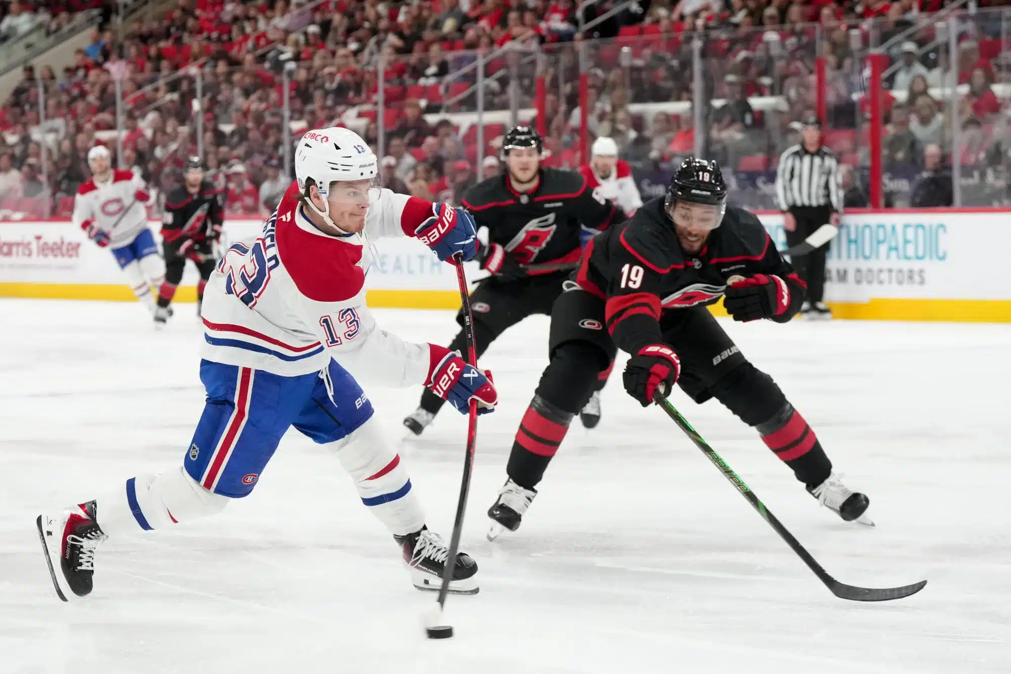May 21, 2026; Raleigh, North Carolina, USA; Montreal Canadiens right wing Cole Caufield (13) shoots the puck defended by Carolina Hurricanes defenseman K'andre Miller (19) during the second period in game one of the Eastern Conference Final of the 2026 Stanley Cup Playoffs at Lenovo Center.