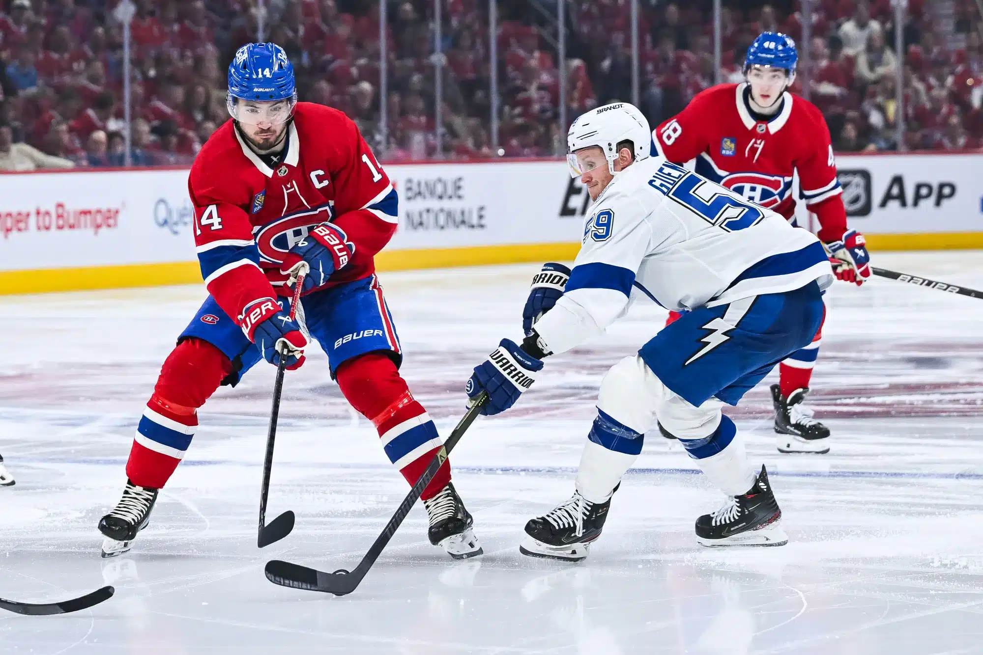 Apr 26, 2026; Montreal, Quebec, CAN; Tampa Bay Lightning center Jake Guentzel (59) defends the puck against Montreal Canadiens center Nick Suzuki (14) during the third period in game four of the first round of the 2026 Stanley Cup Playoffs at Bell Centre. 