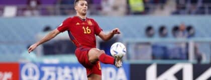 Spain midfielder Rodri (16) kicks the ball against Japan during the second half of a group stage match during the 2022 World Cup at Khalifa International Stadium.