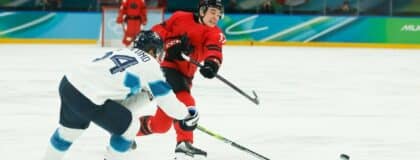 Macklin Celebrini (17) of Canada takes a shot as Mikael Granlund (64) of Finland defends during the third period in a men's ice hockey semifinal during the Milano Cortina 2026 Olympic Winter Games at Milano Santagiulia Ice Hockey Arena