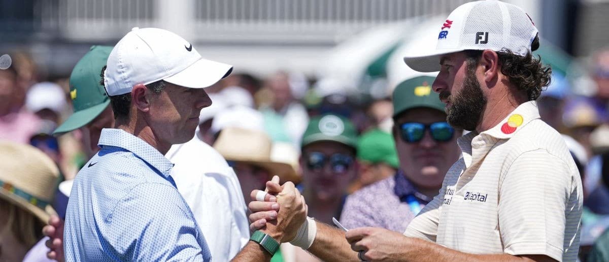 Rory McIlroy greets Cameron Young before teeing off on the first hole during the final round of the Masters Tournament at Augusta National Golf Club.