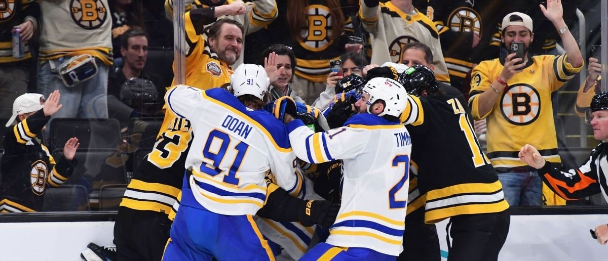 The Boston Bruins and Buffalo Sabres fight along the boards during the third period in game four of the first round of the 2026 Stanley Cup Playoffs at TD Garden