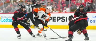 Philadelphia Flyers center Denver Barkey (52) skates with the puck against Carolina Hurricanes left wing Eric Robinson (50) and defenseman Sean Walker (26) during the second period in game two of the second round of the 2026 Stanley Cup Playoffs at Lenovo Center.
