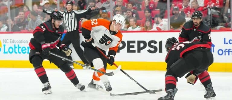 Philadelphia Flyers center Denver Barkey (52) skates with the puck against Carolina Hurricanes left wing Eric Robinson (50) and defenseman Sean Walker (26) during the second period in game two of the second round of the 2026 Stanley Cup Playoffs at Lenovo Center.