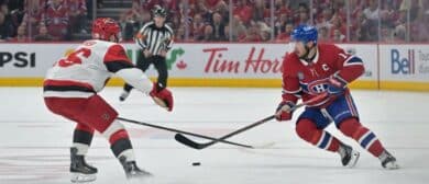 Montreal Canadiens center Nick Suzuki (14) skates against Carolina Hurricanes defenseman Sean Walker (26) during the third period in game three of the Eastern Conference Final of the 2026 Stanley Cup Playoffs at Bell Centre
