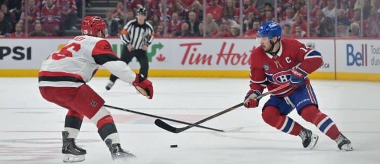 Montreal Canadiens center Nick Suzuki (14) skates against Carolina Hurricanes defenseman Sean Walker (26) during the third period in game three of the Eastern Conference Final of the 2026 Stanley Cup Playoffs at Bell Centre
