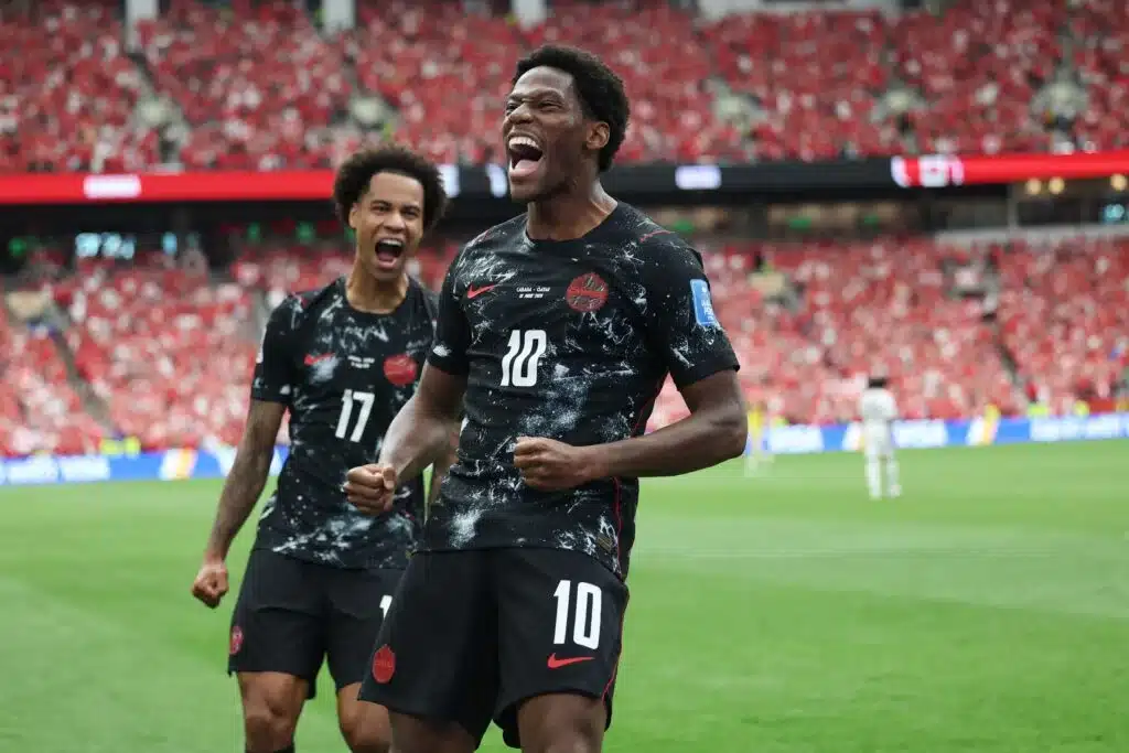 Jonathan David celebrates on the pitch as Canada secured its first ever World Cup victory, beating Qatar 6-0 and going top of Group B with four points after two games played.