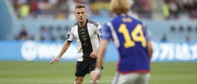 Germany midfielder Joshua Kimmich (6) is defended by Japan forward Junya Ito (14) during a group stage match during the 2022 World Cup at Khalifa International Stadium