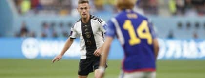 Germany midfielder Joshua Kimmich (6) is defended by Japan forward Junya Ito (14) during a group stage match during the 2022 World Cup at Khalifa International Stadium