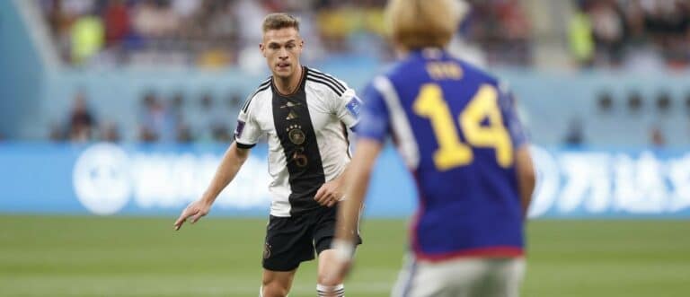 Germany midfielder Joshua Kimmich (6) is defended by Japan forward Junya Ito (14) during a group stage match during the 2022 World Cup at Khalifa International Stadium