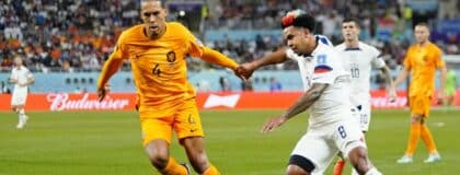Netherlands defender Virgil van Dijk (4) dribbles the ball against United States of America midfielder Weston McKennie (8) during the second half of a round of sixteen match in the 2022 FIFA World Cup at Khalifa International Stadium