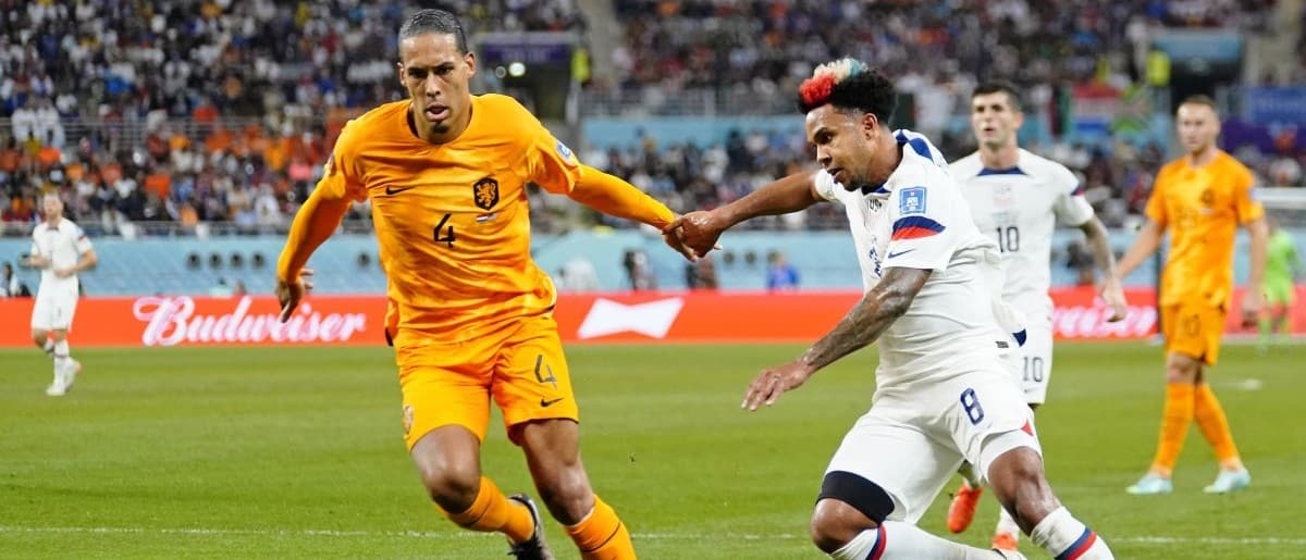 Netherlands defender Virgil van Dijk (4) dribbles the ball against United States of America midfielder Weston McKennie (8) during the second half of a round of sixteen match in the 2022 FIFA World Cup at Khalifa International Stadium