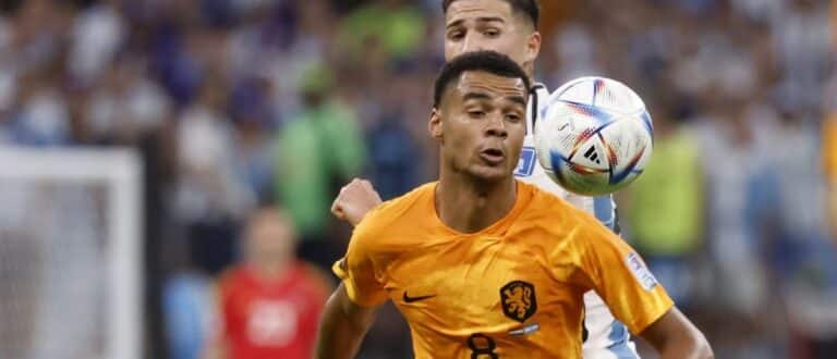 Netherlands forward Cody Gakpo (8) battles for the ball against Argentina midfielder Enzo Fernandez (24) in the quarterfinals of the 2022 FIFA World Cup at Lusail Stadium