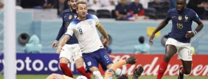England forward Harry Kane (9) shoots against France goalkeeper Hugo Lloris (1) during the first half of a quarterfinal game in the 2022 FIFA World Cup at Al-Bayt Stadium.