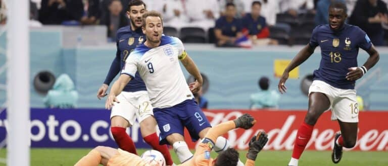 England forward Harry Kane (9) shoots against France goalkeeper Hugo Lloris (1) during the first half of a quarterfinal game in the 2022 FIFA World Cup at Al-Bayt Stadium.