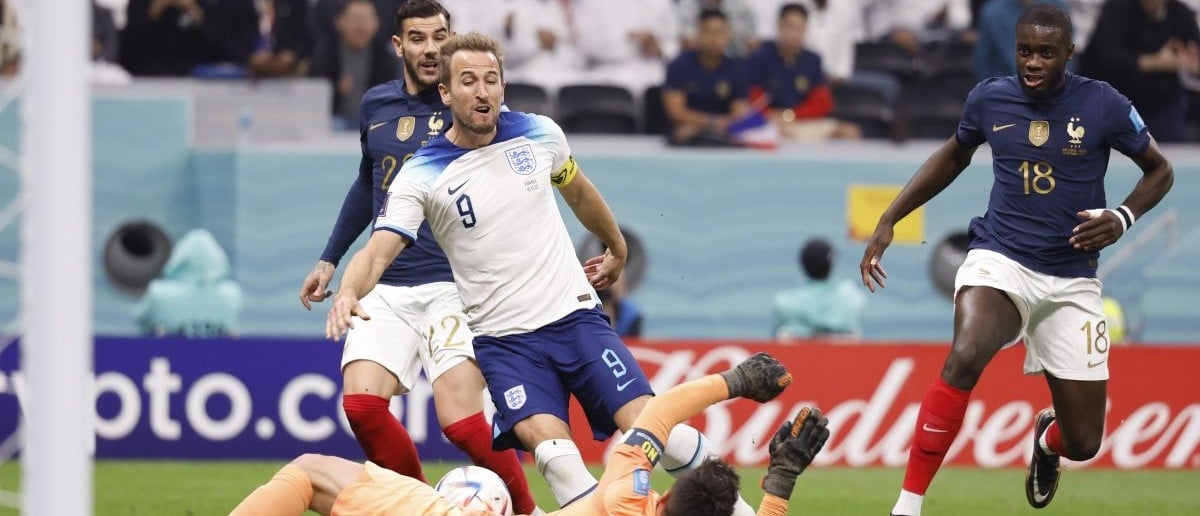 England forward Harry Kane (9) shoots against France goalkeeper Hugo Lloris (1) during the first half of a quarterfinal game in the 2022 FIFA World Cup at Al-Bayt Stadium.