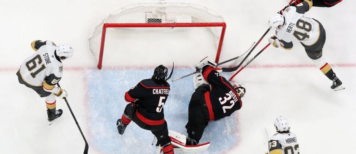 Carolina Hurricanes goaltender Brandon Bussi (32) freezes the puck against Vegas Golden Knights center Tomas Hertl (48) during the third period in game five of the 2026 Stanley Cup Final at Lenovo Center.