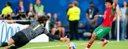 Brazil goalkeeper Alisson Becker (1) looks to block a shot by Morocco forward Ayoube Amaimouni-Echghouyab (21) during a FIFA World Cup Group C match between Brazil and Morocco at New York New Jersey Stadium on Saturday, June 13, 2026, in East Rutherford, New Jersey.
