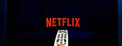 Male hand holding a remote control while watching Netflix on a TV screen