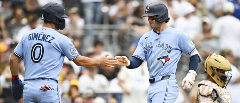 Toronto Blue Jays second baseman Ernie Clement (22) is congratulated by shortstop Andrés Giménez (0) after hitting a two-run home run during the fourth inning against the San Diego Padres at Petco Park.