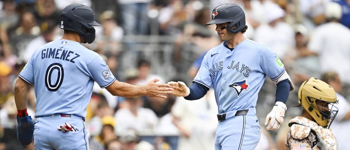 Toronto Blue Jays second baseman Ernie Clement (22) is congratulated by shortstop Andrés Giménez (0) after hitting a two-run home run during the fourth inning against the San Diego Padres at Petco Park.
