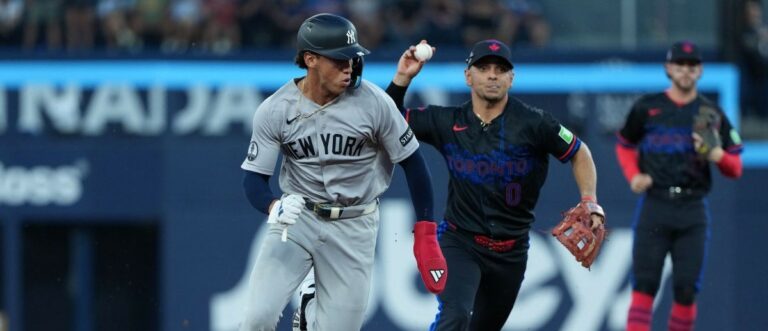 New York Yankees shortstop George Lombard (96) is chased by Toronto Blue Jays shortstop Andres Gimenez (0) against during the third inning at Rogers Centre