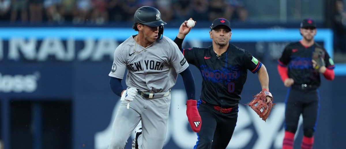 New York Yankees shortstop George Lombard (96) is chased by Toronto Blue Jays shortstop Andres Gimenez (0) against during the third inning at Rogers Centre
