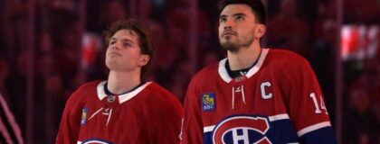 Montreal Canadiens forward Cole Caufield (13) and teammate forward Nick Suzuki (14) during the National Anthem before the game against the Florida Panthers at the Bell Centre. Mandatory Credit: Eric Bolte-Imagn Images
