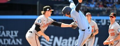 Toronto Blue Jays designated hitter George Springer (4) leaps to elude a tag from Baltimore Orioles shortstop Gunnar Henderson (2) during a baseline rundown in the fourth inning at Rogers Centre
